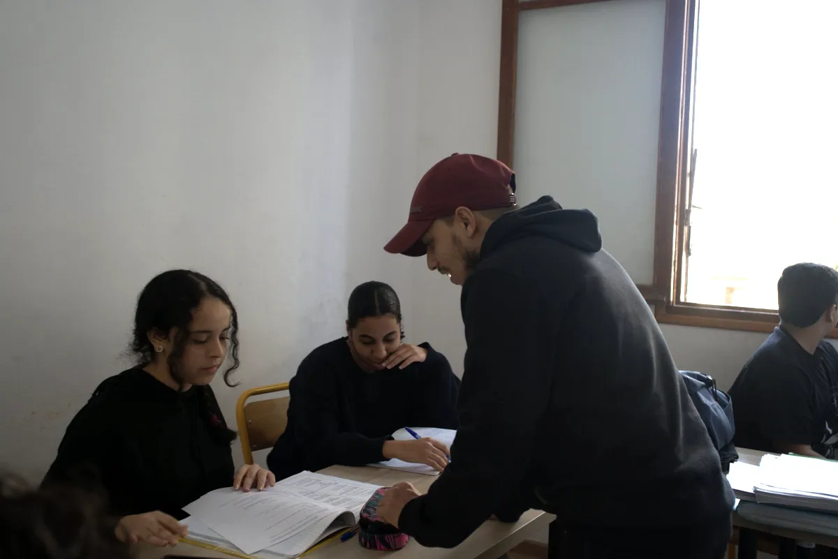 Un enseignant Cap Mission reprenant un exercice avec deux élèves